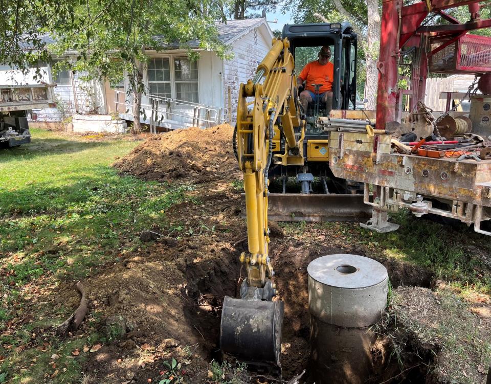 Lynn Rosenquist uses a backhoe to dig out the concrete casing of an old well near Fort Dodge, Iowa.
