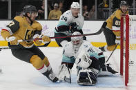 Seattle Kraken goaltender Philipp Grubauer (31) blocks a shot by Vegas Golden Knights defenseman Shea Theodore, left, during the second period of an NHL hockey game Friday, Nov. 25, 2022, in Las Vegas. (AP Photo/John Locher)