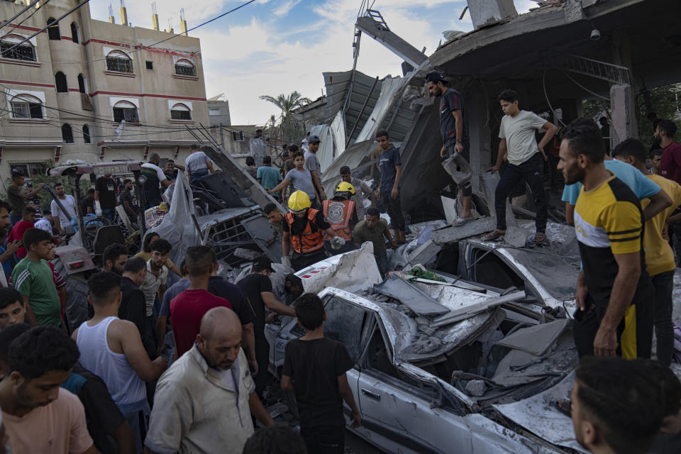 Rescue workers are seen at the site of a building collapse after an airstrike in Khan Younis, Gaza Strip, Saturday, Oct. 21, 2023. (AP Photo/Fatima Shbair)