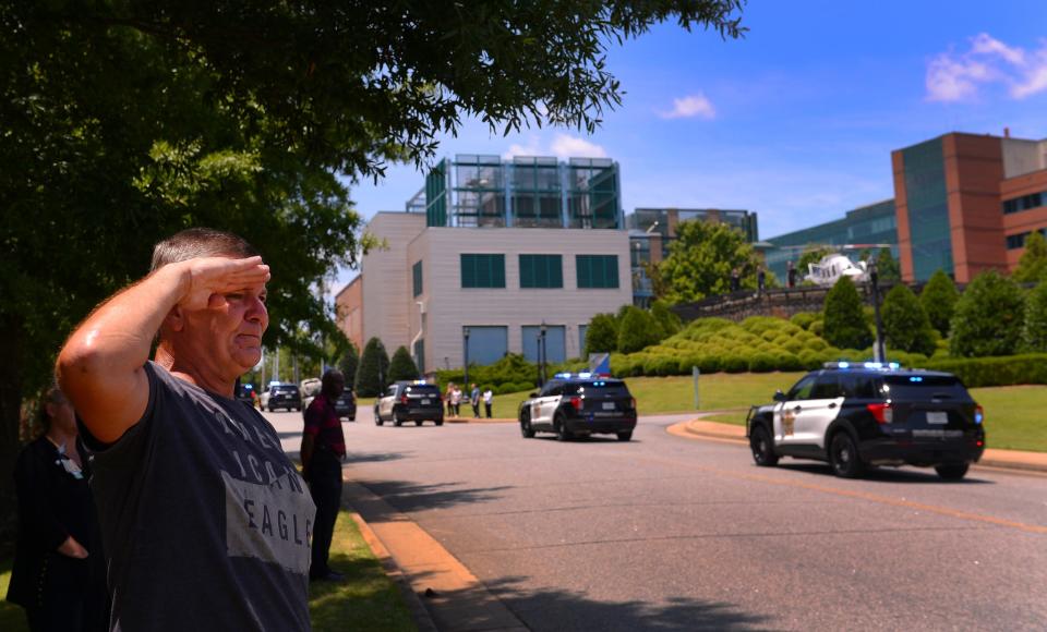 A processional with Spartanburg County Sheriffs Department deputies and Spartanburg Police officers escort the body of Deputy Austin Aldridge from Spartanburg Regional Hospital to Floyd Mortuary, Thursday, June 23, 2022. Wesley Leonard came out to pay his respects. Leonard, of Spartanburg, salutes as the processional passes. He said "the kid was 25, just doing his job."