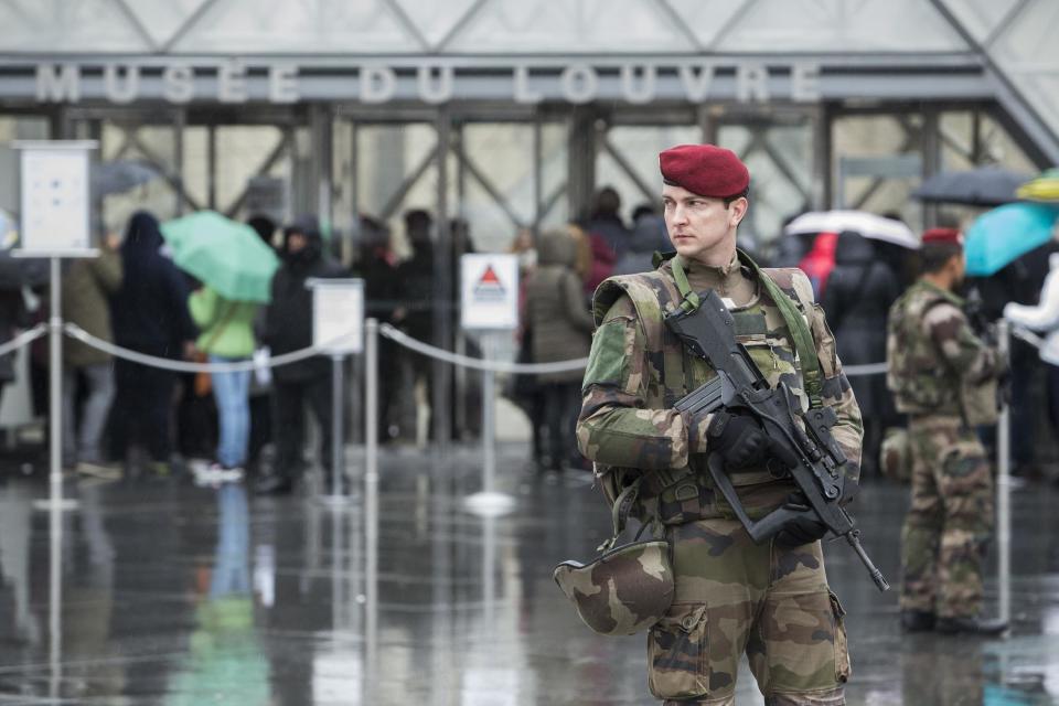 A French soldier patrols in the courtyard of the Louvre museum with the visitor control in background in Paris, Saturday, Feb. 4, 2017. The Louvre in Paris reopened to the public Saturday morning, less than 24-hours after a machete-wielding assailant shouting "Allahu Akbar!" was shot by soldiers, in what officials described as a suspected terror attack.(AP Photo/Kamil Zihnioglu)