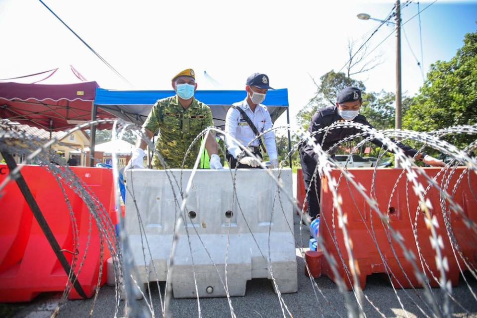 Police and RELA personnel man a roadblock in Sungai Lui, Hulu Langat on April 1, 2020. — Picture by Hari Anggara