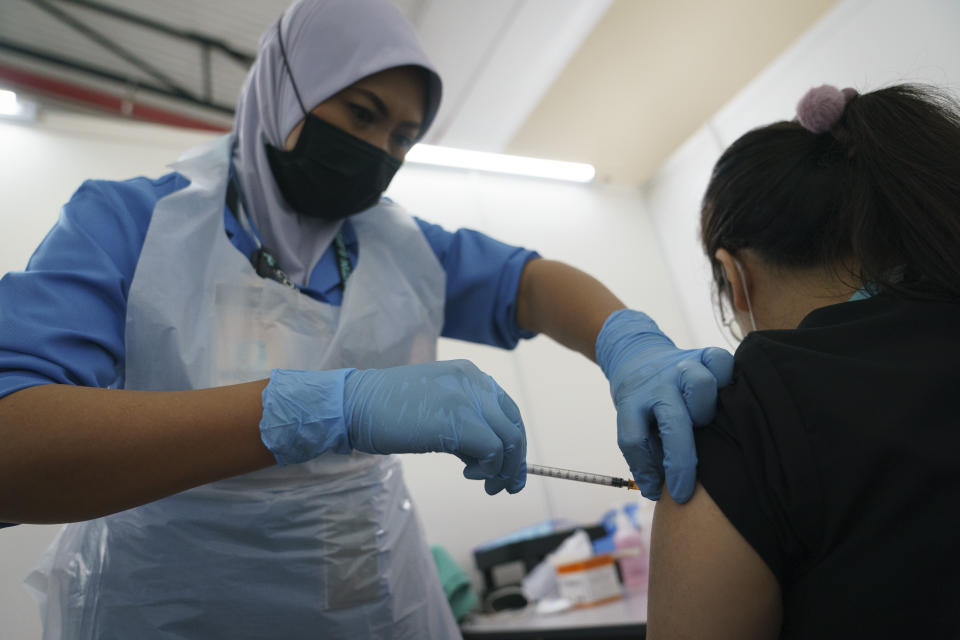 A health worker administers the Pfizer COVID-19 vaccine to a health staff member at a vaccination center in Serdang, outskirt of Kuala Lumpur, Malaysia, Thursday, March 4, 2021. (AP Photo/Vincent Thian)