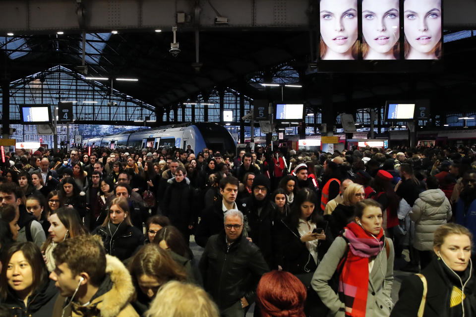 Commuters walk out of a train at the Gare Saint Lazare station in Paris, France, Monday, Dec. 16, 2019. French transport strikes against a planned overhaul of the pension system entered their twelfth day Monday as French president Emmanuel Macron's government remains determined to push ahead with its plans. (AP Photo/Francois Mori)
