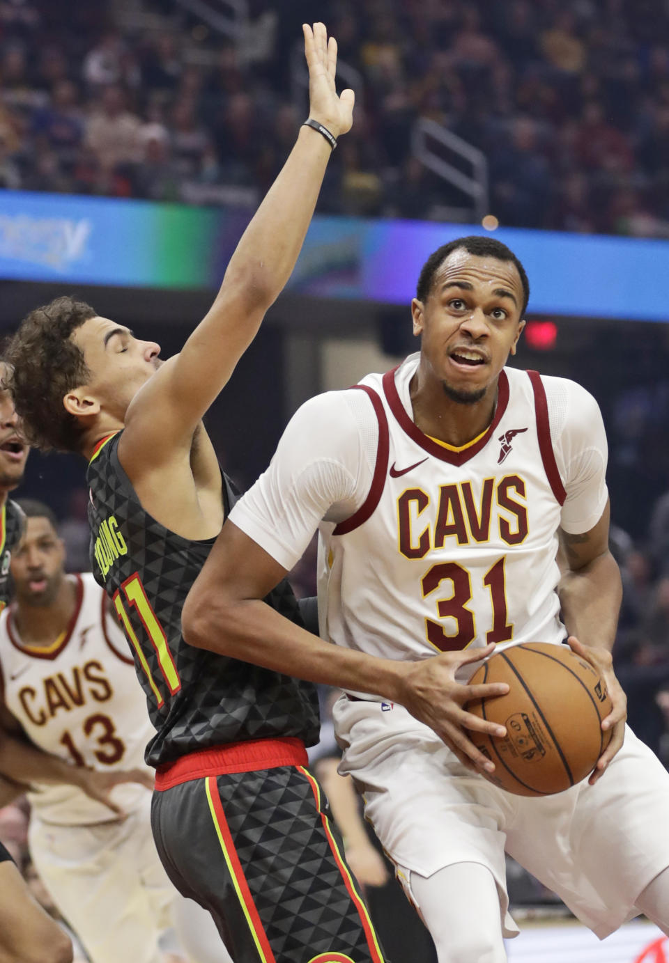 Cleveland Cavaliers' John Henson, right, drives past Atlanta Hawks' Trae Young during the first half of an NBA basketball game Monday, Dec. 23, 2019, in Cleveland. (AP Photo/Tony Dejak)
