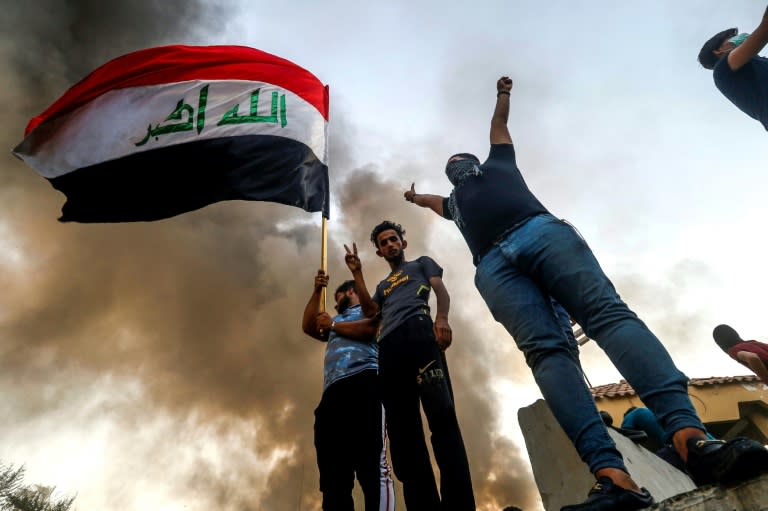 Iraqi protesters wave the national flag in the southern city of Basra on September 7, 2018