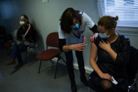 A nurse administrates a Pfizer/Biontech COVID-19 vaccine to a health care worker at the MontLegia CHC hospital in Liege, Belgium, Wednesday, Jan. 27, 2021. (AP Photo/Francisco Seco)