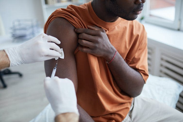 A Black man being vaccinated for COVID