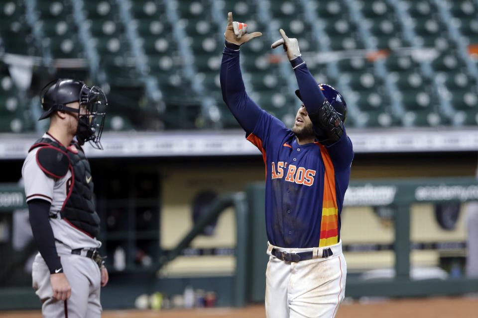 Houston Astros' George Springer, right, celebrates his second home run after scoring in front of Arizona Diamondbacks catcher Carson Kelly, left, during the seventh inning of a baseball game against the Arizona Diamondbacks Sunday, Sept. 20, 2020, in Houston. (AP Photo/Michael Wyke)