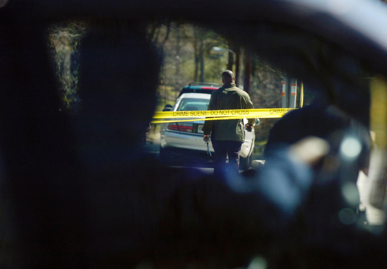 Motorists slow down to watch law enforcement officers at a crime scene at the corner of Canter Road and Lennox Road in Atlanta on Saturday, March 12. (Photo by Davis Turner/Getty Images)