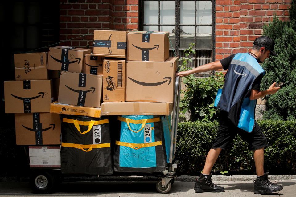 An Amazon delivery worker pulls a delivery cart full of packages during its annual Prime Day promotion in New York City, U.S., June 21, 2021.  REUTERS/Brendan McDermid