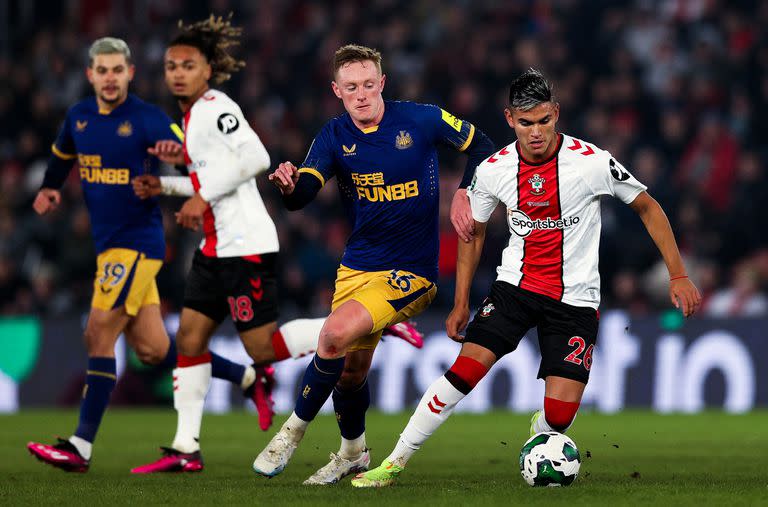 Carlos Alcaraz cubre la pelota frente a la marca de Sean Longstaff en la derrota de Southampton por 1-0 a manos de Newcastle, en la idea de una semifinal por la Copa de la Liga.