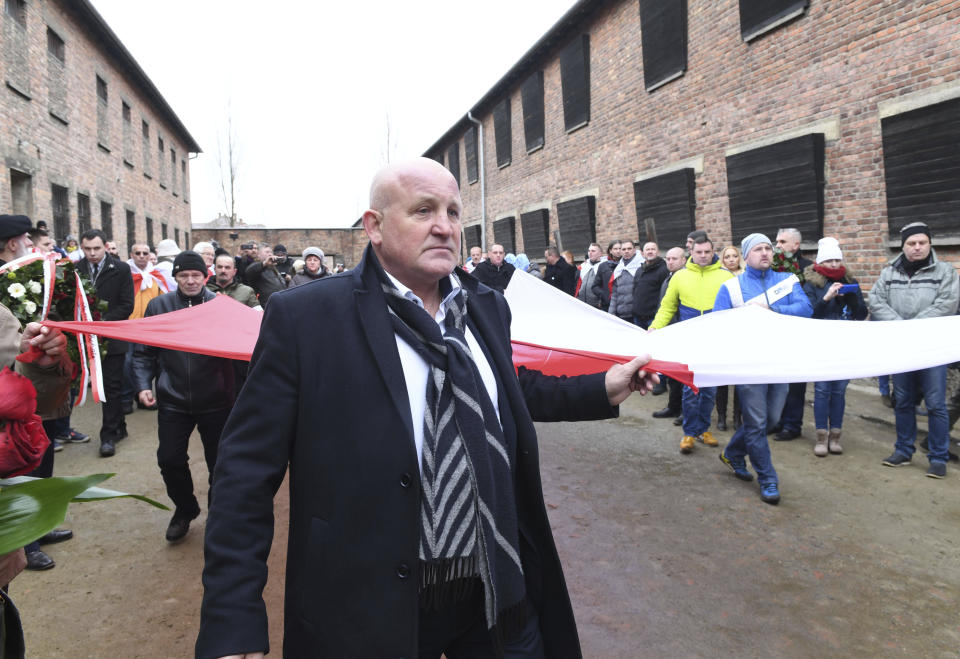 Polish far-right activists enter the former German Nazi death camp Auschwitz-Birkenau, on International Holocaust Remembrance Day in Oswiecim, Poland, Sunday, Jan. 27, 2019.(AP Photo)