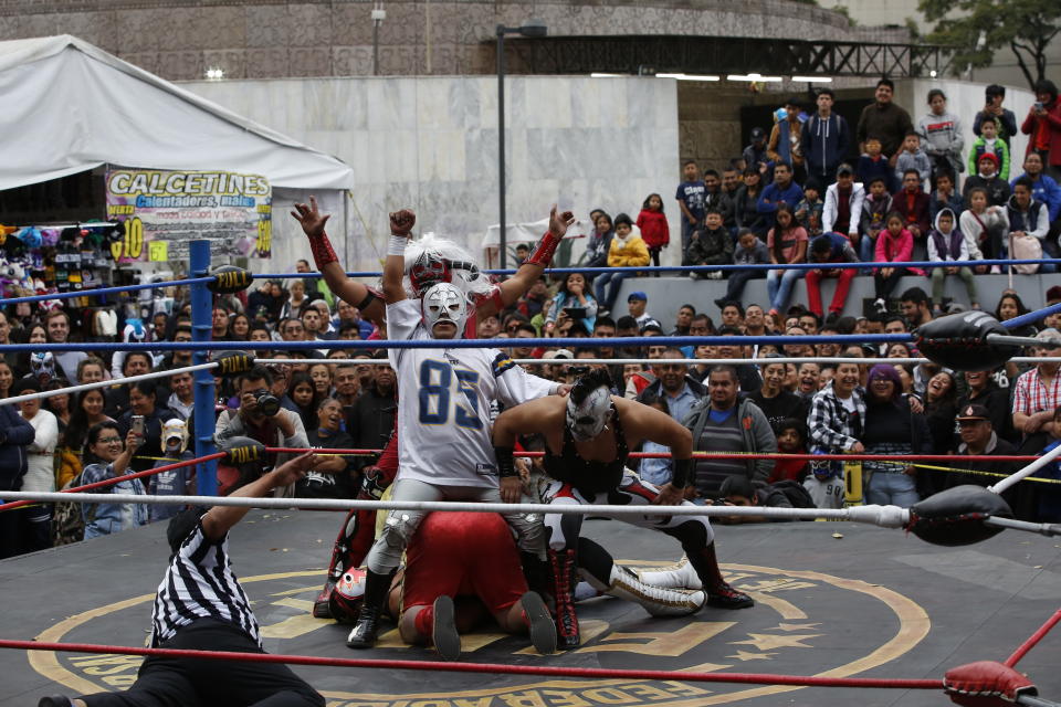 Mexican wrestlers fight during a public bout in Mexico City, Saturday, Dec. 21, 2019. Mexican wrestling, otherwise known as the “lucha libre,” is a highly traditional form of light entertainment masquerading as a ‘sport’. (AP Photo/Ginnette Riquelme)