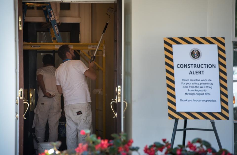 Workers are seen painting inside a West Wing entrance.