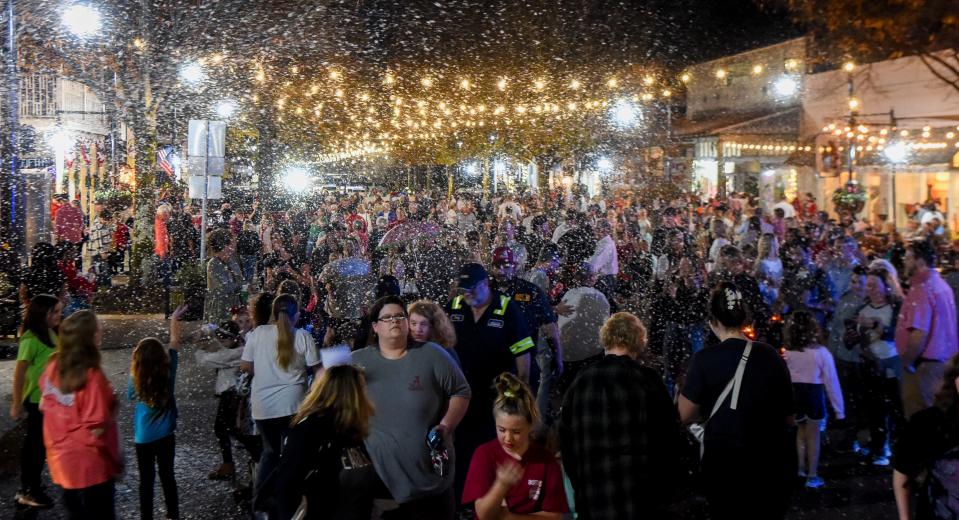 Dec 6, 2022; Tuscaloosa, Alabama, USA;  Northport hosted the annual Dickens Downtown on Main Ave. Tuesday, kicking off the Christmas season. Imitation snow blows over the Main Ave. from two machines, lending the Christmas atmosphere to a night that was warm and muggy. 