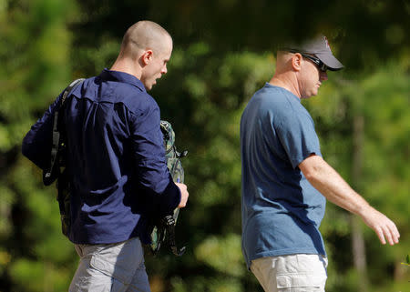 Bowe Bergdahl (L), who was demoted and dishonorably discharged from the U.S. Army for abandoning his post in Afghanistan, wears civilian clothes as he is escorted out of the courthouse at the conclusion of his court martial at Fort Bragg, North Carolina, U.S., November 3, 2017. REUTERS/Jonathan Drake