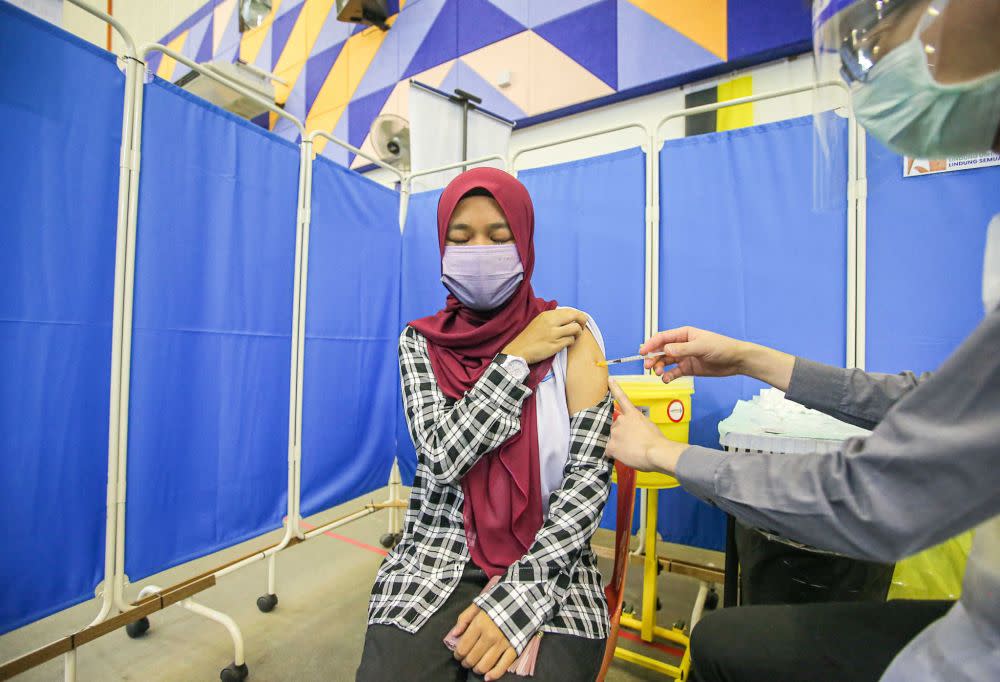 Form Five student Nurul Iman Zulkifly receives her Covid-19 jab at the Kinta Town Hall in Batu Gajah September 21, 2021. — Picture by Farhan Najib