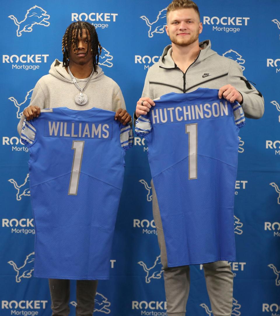 Detroit Lions first round picks receiver Jameson Williams and defensive end Aidan Hutchinson hold up their Lions' jerseys during the news conference Friday, April 29, 2022 at the Detroit Lions practice facility in Allen Park.