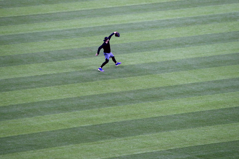 An unidentified player throws in the outfield at Globe Life Field, home of the Texas Rangers baseball team, in Arlington, Texas, Monday, June 1, 2020. The coronavirus pandemic has forced universities, leagues and franchises to evaluate how they might someday welcome back fans. While opinions vary from sport to sport, nation to nation and even state to state, one thing seems clear: Social distancing is very much a sure bet when fans return. (AP Photo/LM Otero)