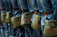 Participants dressed in replica red army uniforms carry bags sporting the portrait of former Chinese leader Mao Zedong during a Communist team-building course extolling the spirit of the Long March, organised by the Revolutionary Tradition College, in the mountains outside Jinggangshan, Jiangxi province, China, September 14, 2017. REUTERS/Thomas Peter