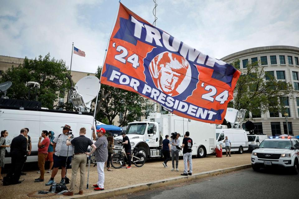 PHOTO: A supporter of Donald Trump carries a large flag outside the E. Barrett Prettyman U.S. District Court House ahead of Trump's arrival on Aug. 3, 2023, in Washington, D.C. (Chip Somodevilla/Getty Images)