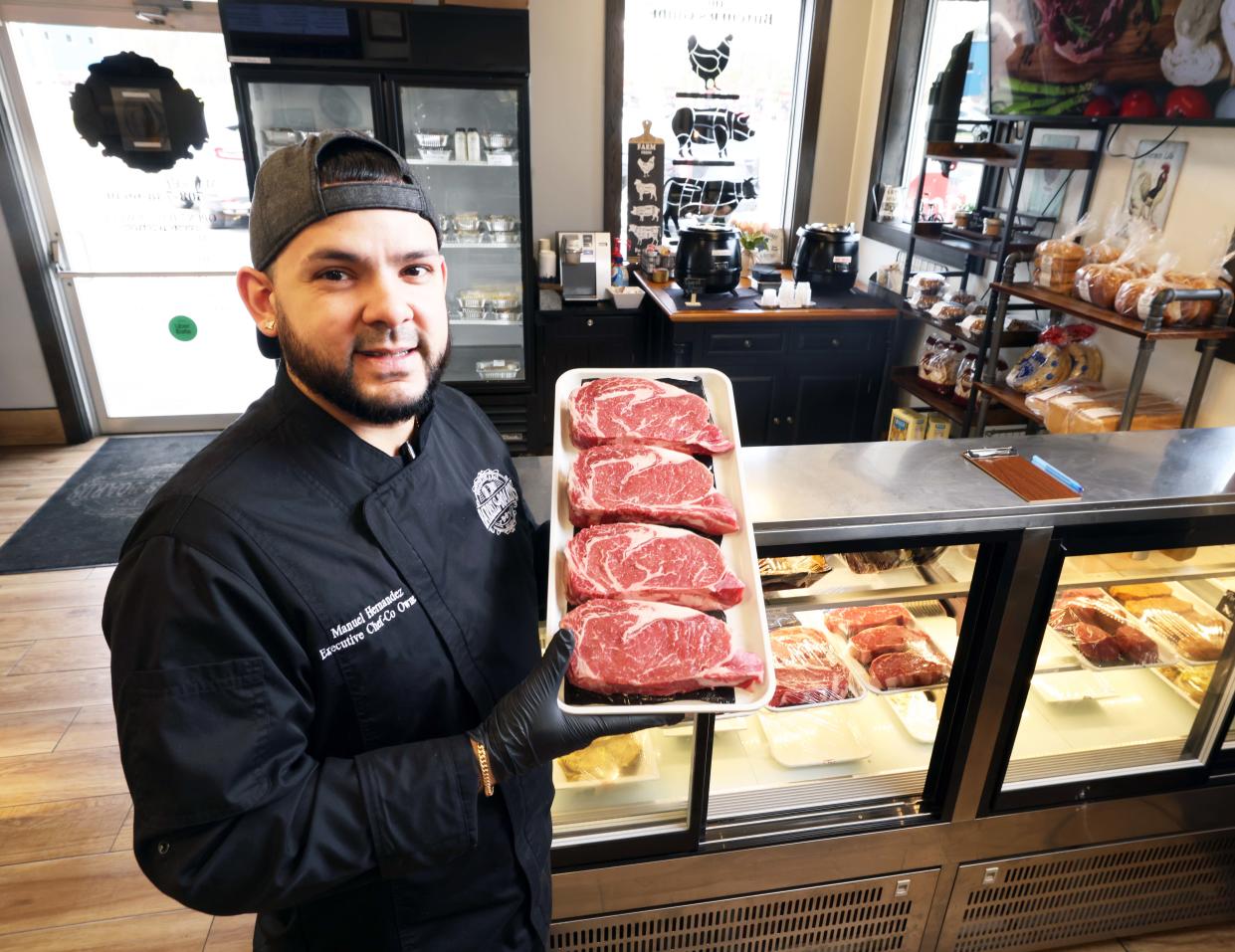Manuel Hernandez, executive chef and co-owner of Barrels & Boards Restaurant and Marketplace in Raynham holds a tray of beef filets on Wednesday, April 10, 2024.