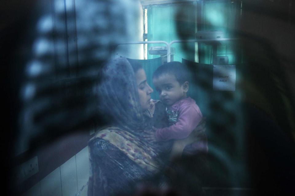 In this picture taken on 7 November 2023, a doctor (not pictured) examines the X-ray of child with breathing difficulties at the emergency ward of the government-run Chacha Nehru Bal Chikitsalaya children hospital in New Delhi (AFP via Getty Images)