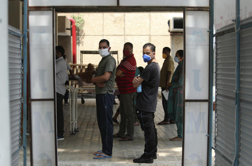 Indians wearing face masks wait to consult doctors at COVID-19 screening facility inside a government run hospital in Jammu, Saturday, June 27, 2020. India is the fourth hardest-hit country by the pandemic in the world after the U.S., Russia and Brazil. (AP Photo/Channi Anand)