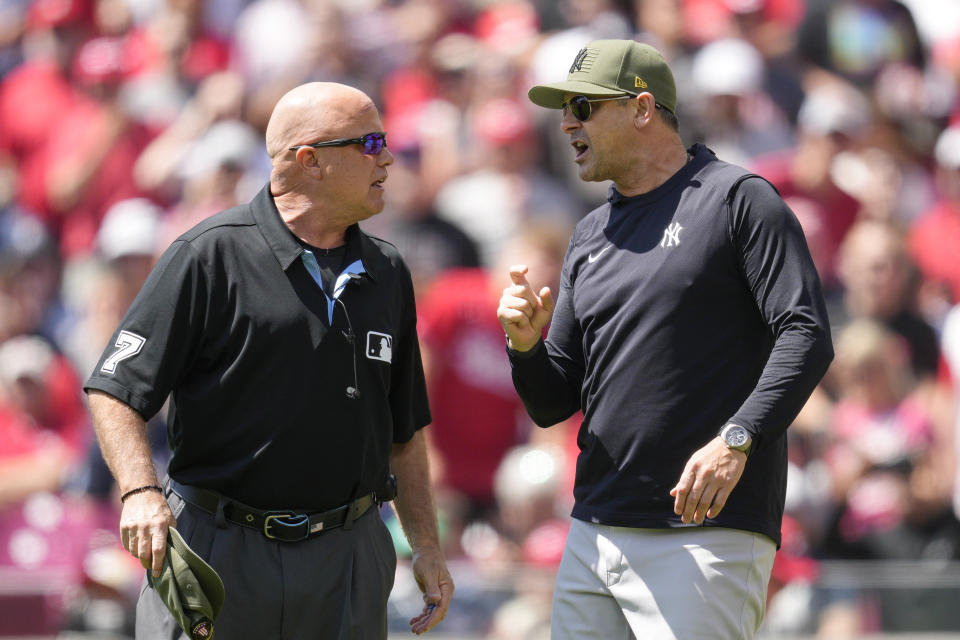 New York Yankees manager Aaron Boone, right, speaks with umpire Brian O'Nora in the first inning of a baseball game against the Cincinnati Reds in Cincinnati, Sunday, May 21, 2023. Boone was ejected by home plate umpire Emil Jimenez. (AP Photo/Jeff Dean)