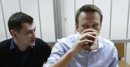 Russian opposition leader and anti-corruption blogger Alexei Navalny (R) and his brother and co-defendant Oleg attend a court hearing in Moscow December 19, 2014. REUTERS/Maxim Zmeyev