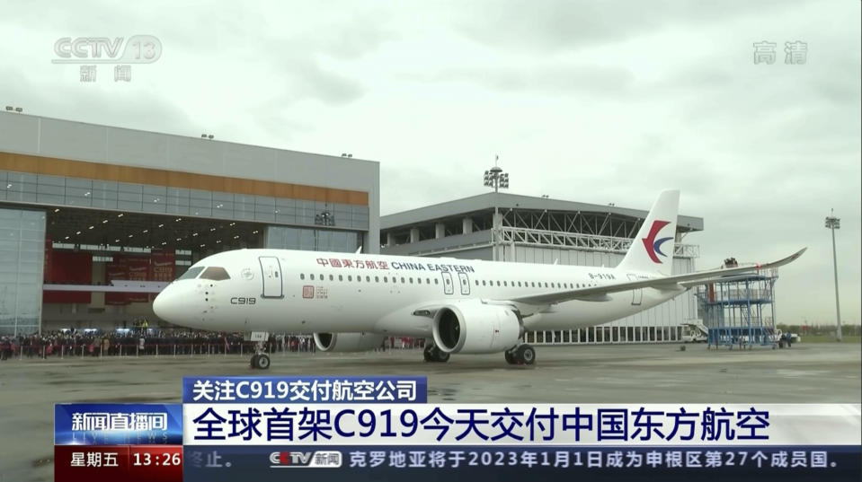 In this image taken from video footage run by China's CCTV, the Chinese made C919 jet with the delivery for China Eastern Airlines Ltd is seen on the tarmac of the Shanghai Pudong Airport before take off on Friday, Dec. 9, 2022. The Chinese airline on Friday became the first customer to take delivery of a long-range jetliner produced by a state-owned manufacturer set up to try to compete with Boeing and Airbus, state TV reported. Words on screen reads "World first C919 delivered to China Eastern Airline." (CCTV via AP)