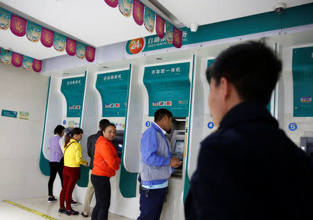 People use bank machine in a branch of the Agricultural Bank of China in the town of Nansan, Yunnan province, China, March 12, 2017. REUTERS/Thomas Peter