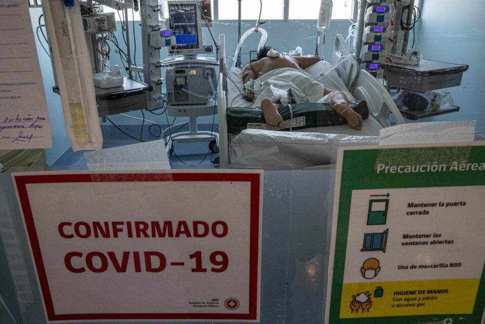 A COVID-19 patient lies in the ICU at the Posta Central Hospital in Santiago, Chile, Thursday, Dec. 24, 2020, on the same day the first shipment of coronavirus vaccines arrived from Pfizer and its German partner, BioNTech. (AP Photo/Esteban Felix)