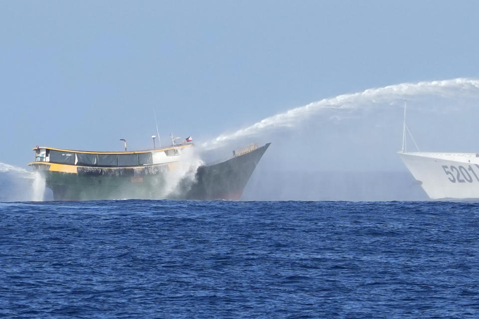Philippine resupply vessel Unaizah May 4, left, is hit by two Chinese coast guard water canons as they tried to enter the Second Thomas Shoal, locally known as Ayungin Shoal, in the disputed South China Sea Tuesday, March 5, 2024. (AP Photo/Aaron Favila)