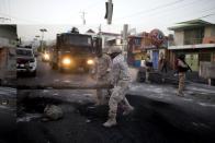 <p>National police officers remove a barricade in the street during a protest over the cost of fuel in Port-au-Prince, Haiti, Saturday, July 7, 2018. (Photo: Dieu Nalio Chery/AP) </p>