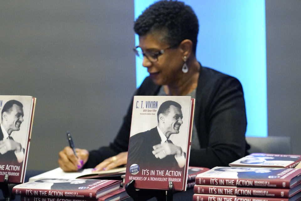 Denise Morse autographs a book about her father, the late C.T. Vivian, on Wednesday, May 26, 2021, at the Mississippi Civil Rights Museum in Jackson, Miss. Mississippi's capital city honored the civil rights activism of the late Rev. C.T. Vivian 60 years after he and other Freedom Riders were arrested upon arrival in Jackson as they challenged segregation in interstate buses and bus terminals across the American South. Jackson's current mayor declared Wednesday as C.T. Vivian Day. (AP Photo/Rogelio V. Solis)