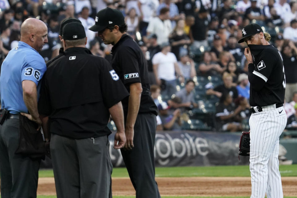 Chicago White Sox starting pitcher Michael Kopech, right, wipes face while umpires confer during the second inning of the team's baseball game against the Baltimore Orioles in Chicago, Friday, June 24, 2022. (AP Photo/Nam Y. Huh)