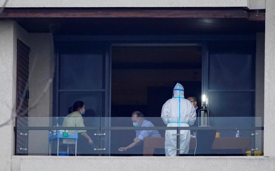 A member of the World Health Organisation team tasked with investigating the origins of Sars-Cov-2 undergoes a blood test on the balcony of his hotel  - REUTERS/Aly Song