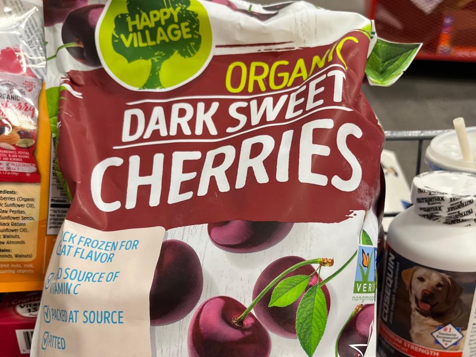 white and red bag of dark sweet cherries in red costco cart