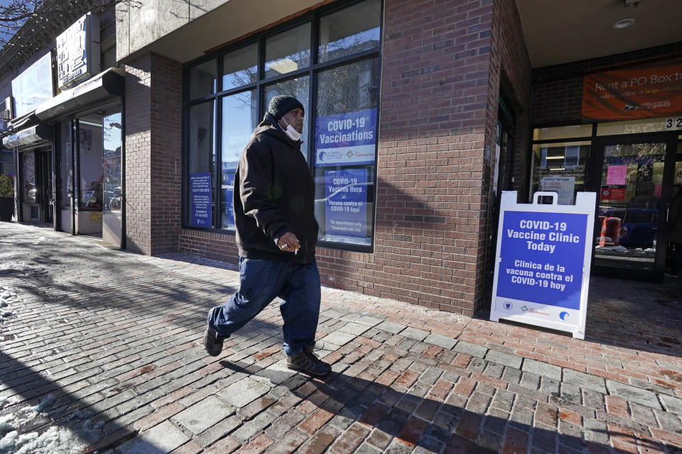 A man walks by the recently opened COVID-19 vaccination site in Chelsea, Mass. Feb. 8, 2021. Chelsea's vaccination sites are limited by Massachusetts' eligibility rules, which only recently expanded to persons 65 or older, as well as people with two or more serious medical conditions. (AP Photo/Elise Amendola)