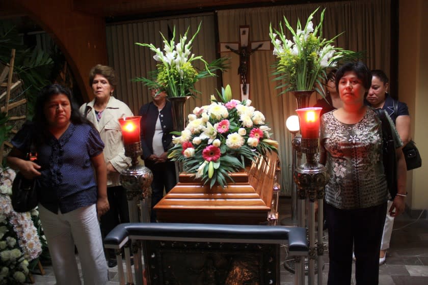 Relatives, friends and journalists stand beside the coffin of slain journalist Regina Martinez during her wake in Xalapa, Mexico, late Sunday April 29, 2012. The Mexican government's human rights commission said Sunday that it will investigate the apparent slaying of a correspondent for Proceso newsmagazine who often wrote about drug trafficking. Police found the body of Martinez on Saturday inside the bathroom of her home in the Veracruz state capital, Xalapa. (AP Photo/Felix Marquez)