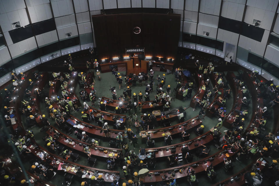 Protesters gather inside the meeting hall of the Legislative Council in Hong Kong, Monday, July 1, 2019. Protesters in Hong Kong took over the legislature's main building Friday night, tearing down portraits of legislative leaders and spray painting pro-democracy slogans on the walls of the main chamber. (AP Photo/Kin Cheung)
