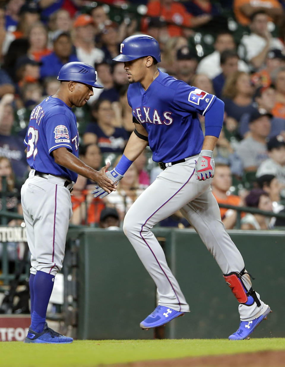 Texas Rangers third base coach Tony Beasley, left, congratulates Ronald Guzman, right, as he rounds third base on his home run during the eighth inning of a baseball game against the Houston Astros on Wednesday, Sept. 18, 2019, in Houston. (AP Photo/Michael Wyke)