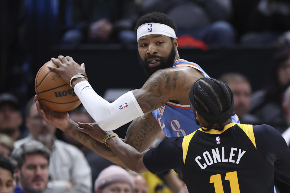 Los Angeles Clippers forward Marcus Morris Sr. (8) looks to pass the ball around Utah Jazz guard Mike Conley (11) in the first quarter of an NBA basketball game Friday, March 18, 2022, in Salt Lake City. (AP Photo/Rob Gray)