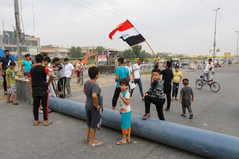 Iraqi demonstrators block the road during ongoing anti-government protests, in Baghdad