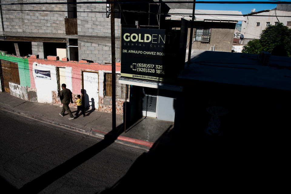 A dental worker, one of hundreds in the city, walks hand in hand with a child in the early morning in Los Algodones, Baja California, Mexico, on Oct. 23, 2019. (Photo: Ash Ponders for HuffPost)