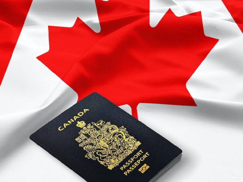 062922-passport_of_Canada_on_the_top_of_an_satin_canadian_flag