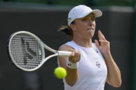 Poland's Iga Swiatek returns the ball to France's Alize Cornet during a third round women's singles match on day six of the Wimbledon tennis championships in London, Saturday, July 2, 2022. (AP Photo/Kirsty Wigglesworth)