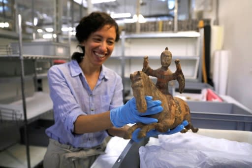 Curator Morag Wilhelm holds an artefact which belonged to Sigmund Freud at the Israel Museum in Jerusalem on July 12, 2018